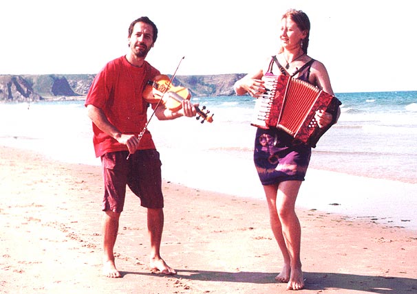 Photo of Phil & Sorrel on beach with instruments